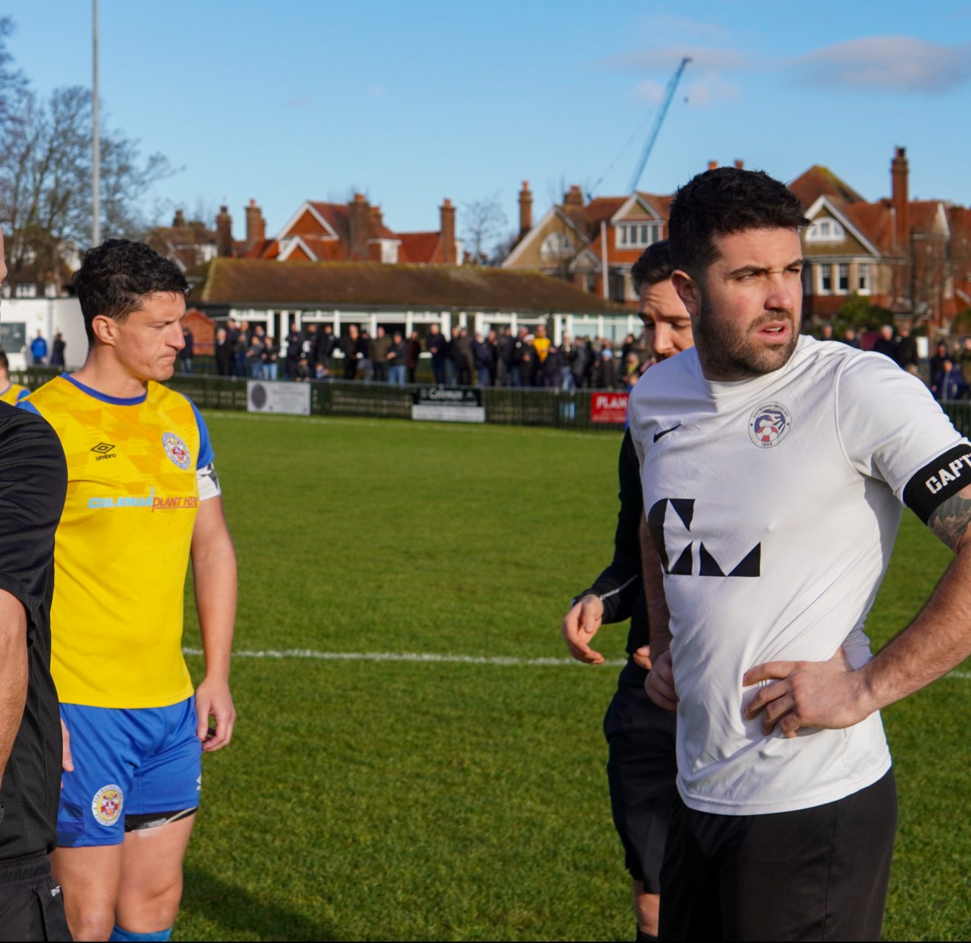 Frankie Chappell of Eastbourne Town and Sam Cole of Eastbounre United with match officials for coin toss.